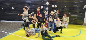 grupa uczniów na tle układu planetarnego