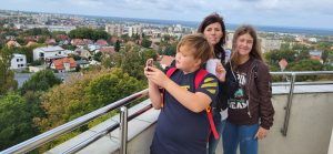 dwoje uczniów i nauczyciel na tle panoramy miasta