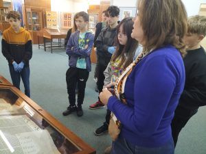 uczniowie w muzeum słuchają opowieści o historii książki i ilustracji