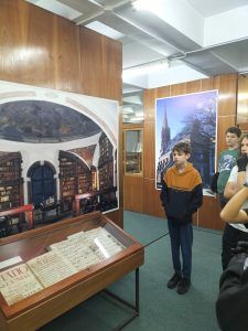 uczniowie w muzeum słuchają opowieści o historii książki i ilustracji