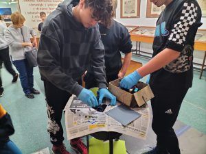 Uczniowie uczestniczą w warsztatach graficznych z wykorzystaniem prasy introligatorskiej do złoceń