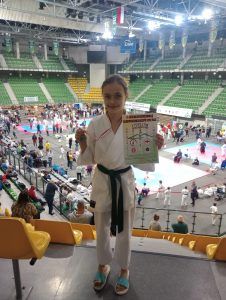 uczennica z medalem w konkurencji zawodniczej karate