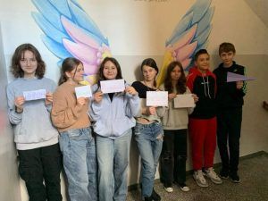 grupa uczniów z kartkami ze swoim imieniem