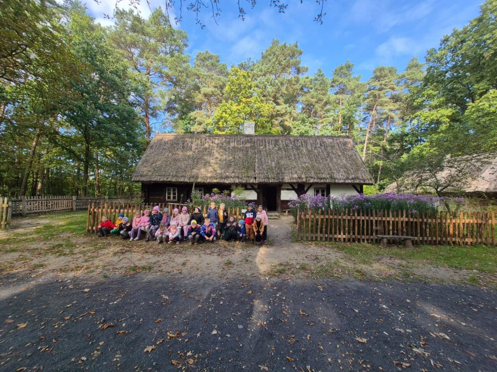 uczniowie przed chatą w skansenie