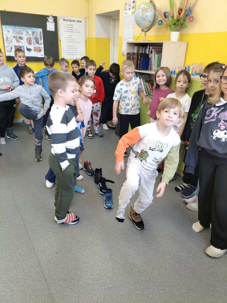 Grupa dzieci ustawia swoje buty w jednym rzędzie jako wróżbę andrzejkową.