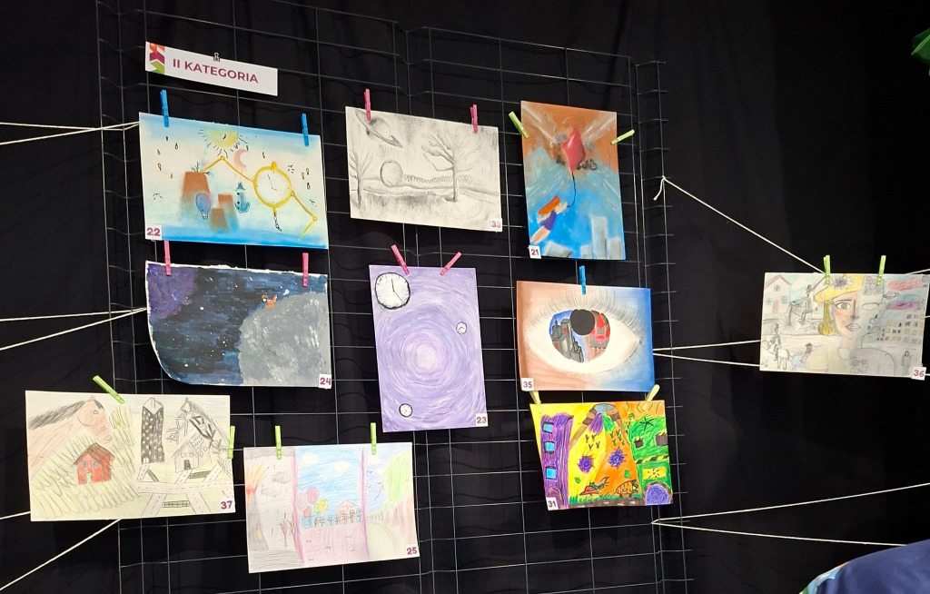 Na tablicy wiszą prace wykonane przez uczestników konkursu. 